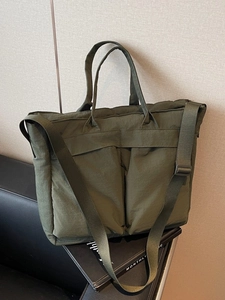 Large olive green nylon tote bag with front pockets and adjustable shoulder strap