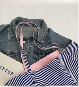 Detail der blau-weiß gestreiften Canvas-Tasche mit robusten rosa gewebten Tragegriffen
