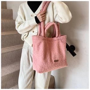 Close-up of pink fluffy tote bag showing lamb wool texture and double handle design