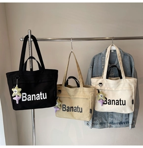 Drei Canvas-Einkaufstaschen in Schwarz, Khaki und Creme mit Stern-Anhängern am Haken