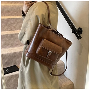 Detail view of deep brown vintage tote bag with contrast stitching and metal buckle