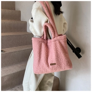 Detail view of pink fuzzy tote bag showing soft plush texture and leather logo patch