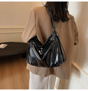 Detail of a large black hobo bag with contrast white stitching and silver hardware