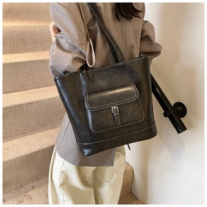 Detail of dark grey retro tote bag featuring high-contrast white stitching and large front pocket