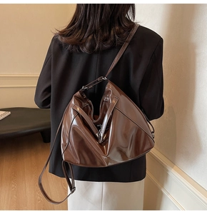 Brown glossy leather tote bag styled with dark blazer and white skirt for fall