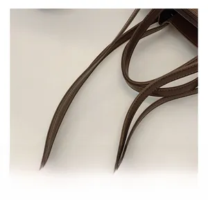 Close-up of durable double leather shoulder straps with fine stitching on a dark brown tote