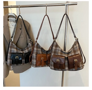 Detail of vintage wool plaid underarm bags with stylish dual leather pockets and metal buckles