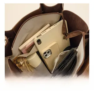 Macro view of large brown leather tote interior showing tablet and daily essentials