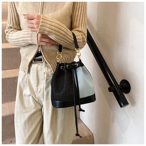 Detail of fabric patchwork bucket bag with drawstring closure and gold metal hardware