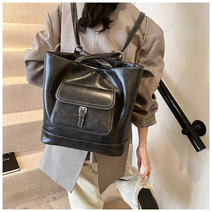 Detail of black tote backpack with vintage flap pocket and white contrast stitching