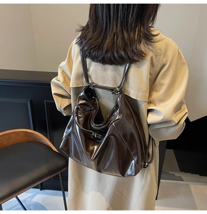 Close-up of a dark brown glossy leather tote bag showing high-capacity design and texture