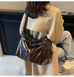 Deep brown vintage tote bag in glossy leather worn by a model with a khaki trench coat