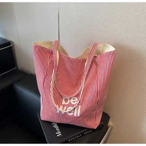 Detailansicht der rot gestreiften Canvas-Tasche mit be well Text auf Ledersofa