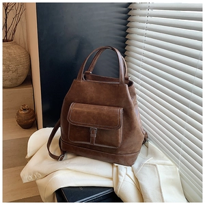 Detail of vintage dark brown faux leather tote bag with flap pocket on white blazer
