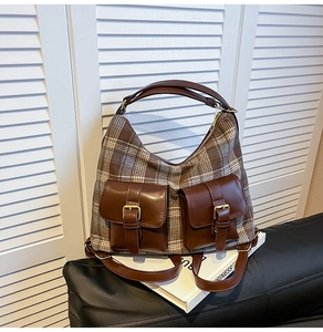 Close-up of retro plaid wool fabric and dual flap pockets with gold buckles on tote bag