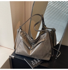 Detail of dark taupe oil wax tote bag showing decorative buckle and silver hardware
