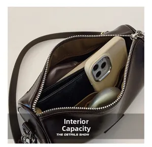 Vue macro de la capacité interne montrant téléphone, portefeuille et écouteurs dans le sac