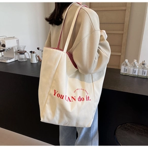 Detail der weißen Canvas-Tasche mit rot gestreiftem Futter und You CAN do it Aufdruck