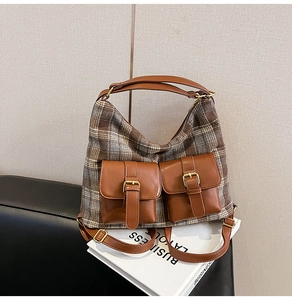 Macro detail of plaid fabric bag with brown leather pockets and brass buckle accents