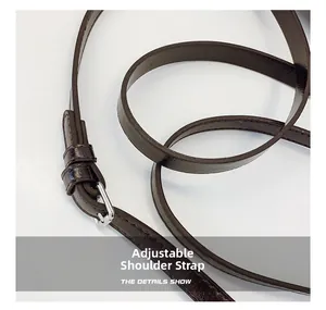 Détail de la bandoulière réglable en cuir marron chocolat avec boucle argentée