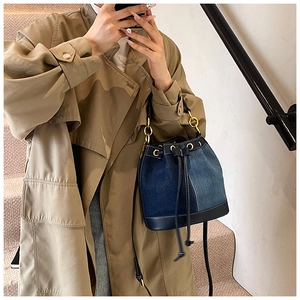 Close-up of denim bucket bag with patchwork blue tones and gold hardware details