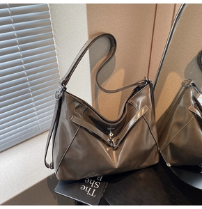 Close-up of olive brown oil-wax leather tote bag with V-strap and metal details