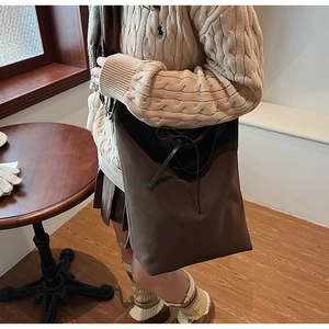 Détail du sac cabas marron foncé avec texture en daim et fermeture par lien en cuir