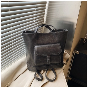 Detail of dark gray tote bag with contrast stitching and vintage matte leather texture