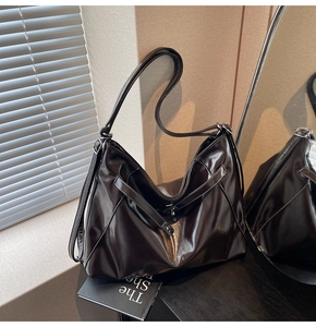 Detail of vintage large tote bag in dark glossy leather with reflective mirror effect