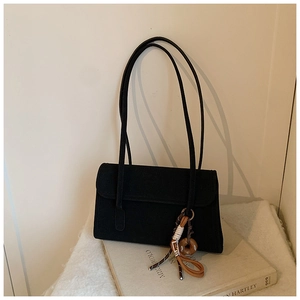 Detailed view of black vintage matte shoulder bag with unique decorative pendant
