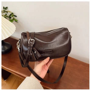 Gros plan d'un sac bandoulière cylindrique en cuir marron poli avec fermeture éclair
