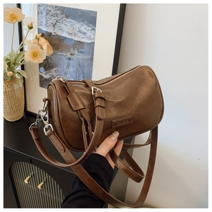 Gros plan d'un sac cylindre en cuir marron avec texture vintage et fermeture éclair en métal
