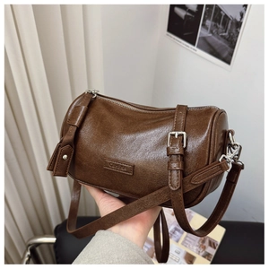 Détail du sac Boston en cuir marron foncé avec zip argenté et logo en relief