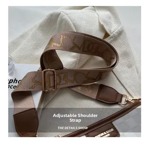 Detail of adjustable woven shoulder strap with retro pattern and gold metal hardware