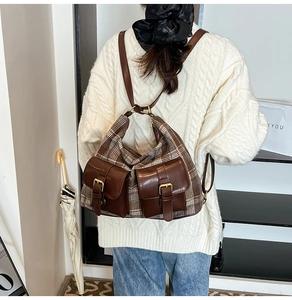 Detail of vintage plaid backpack with double front pockets and brown leather straps