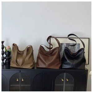 Chic hobo bags in khaki, coffee, and black displayed on a vintage cabinet shelf