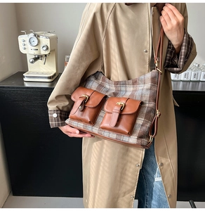 Detail of vintage plaid shoulder bag with brown leather pockets and metal buckle