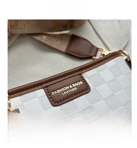Detailed view of white checkered bucket bag with leather trim and wide jacquard strap