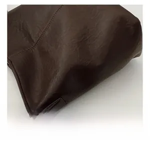 Detailed macro shot of dark brown leather texture with natural wrinkled grain finish