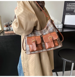 Detail shot of a vintage plaid shoulder bag with brown faux leather pockets and metal buckles