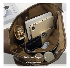 Spacious interior of brown leather tote bag with iPad, books, and zipper pocket