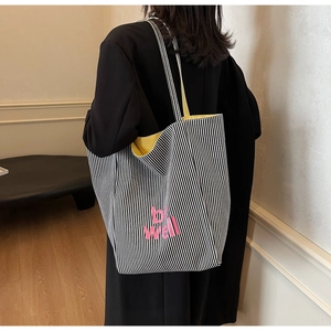 Detail der gestreiften Canvas-Tasche mit pinkem 'be well' Text und gelbem Futter