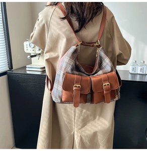 Detail showing the retro plaid fabric patchwork and dual front pockets on the brown bag