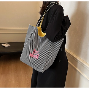 Detail der gestreiften Canvas-Tasche mit gelbem Futter und pinkem be well Text
