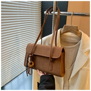 Detail of vintage matte brown shoulder bag with a unique wooden ring charm accessory