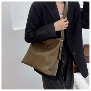 Detailed shot of olive brown large tote bag with adjustable wide shoulder strap on model