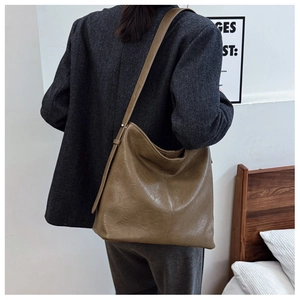 Close-up of retro brown hobo bag with soft pleated texture and adjustable strap