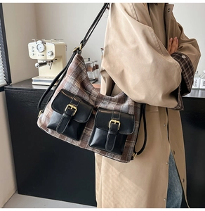 Detail of retro plaid shoulder bag with dual leather pockets and metal buckle closures