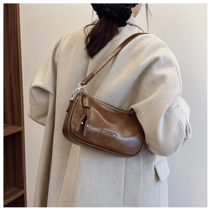 Gros plan d'un sac porté épaule en cuir marron avec fermeture éclair et franges