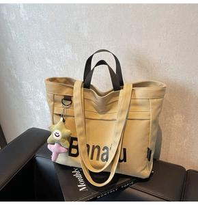 Detail der khakifarbenen Canvas-Tasche mit Banana-Print und Stern-Plüschanhänger